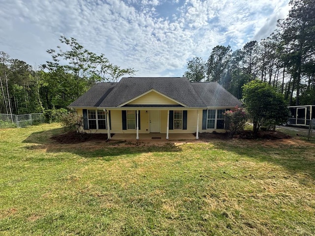 view of front of home with fence, covered porch, and a front yard
