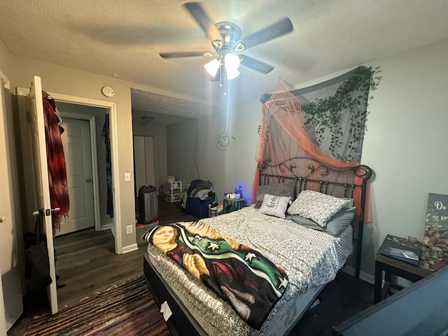 bedroom featuring a textured ceiling, ceiling fan, and dark wood-type flooring