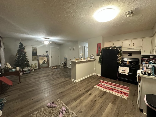 kitchen with black appliances, kitchen peninsula, dark hardwood / wood-style floors, a textured ceiling, and white cabinetry