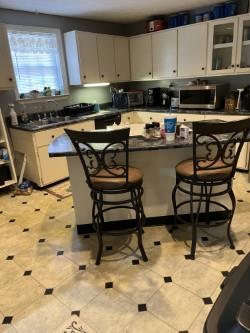 kitchen with white cabinets, a center island, sink, and a breakfast bar area