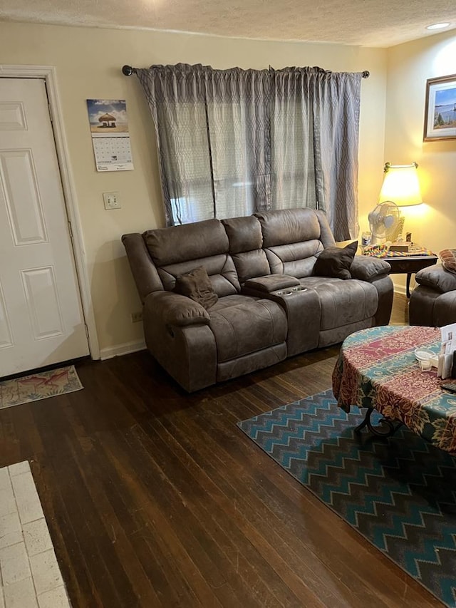 living room with dark wood-type flooring and a textured ceiling