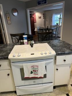 kitchen featuring white cabinets, light tile patterned flooring, and white electric range