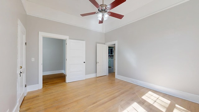 unfurnished bedroom featuring ceiling fan, ornamental molding, light wood-style flooring, and baseboards