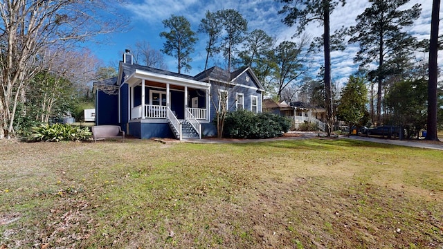 view of front of home featuring a chimney and a front yard