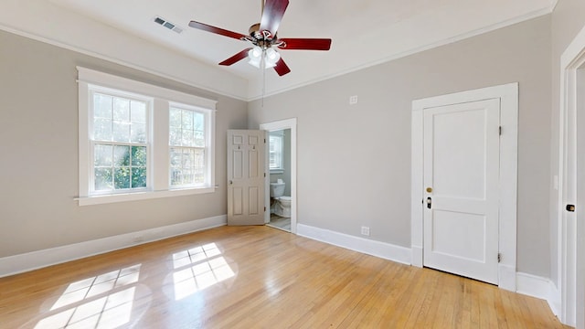 spare room featuring visible vents, baseboards, a ceiling fan, ornamental molding, and light wood-style floors