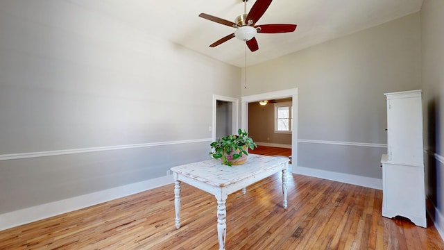 unfurnished dining area with hardwood / wood-style flooring, baseboards, and a ceiling fan