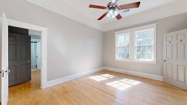 spare room with light wood-style flooring, visible vents, baseboards, and ceiling fan