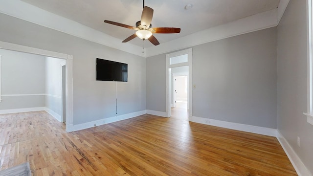 unfurnished room featuring light wood-type flooring, a ceiling fan, and baseboards