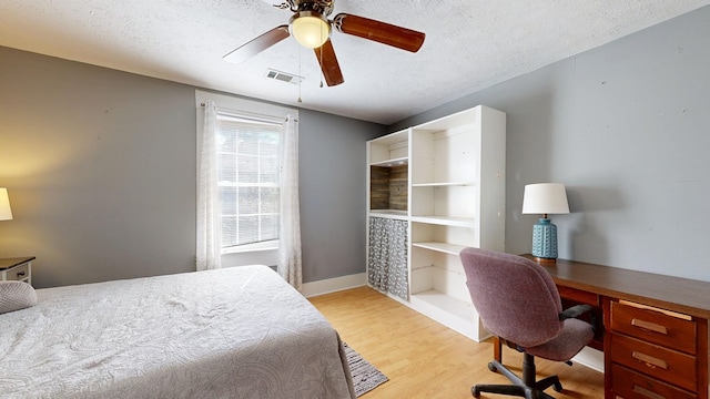 bedroom with visible vents, ceiling fan, a textured ceiling, light wood-type flooring, and baseboards