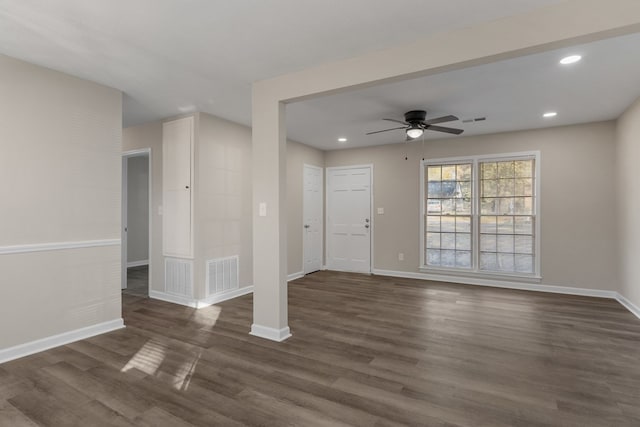 unfurnished living room with ceiling fan and dark wood-type flooring