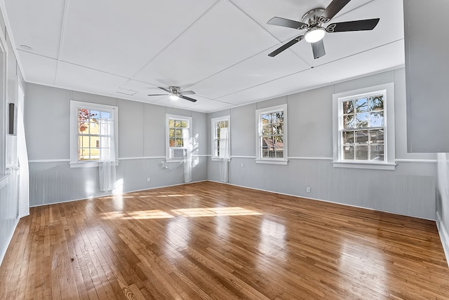 unfurnished room featuring a wealth of natural light, ceiling fan, and wood-type flooring