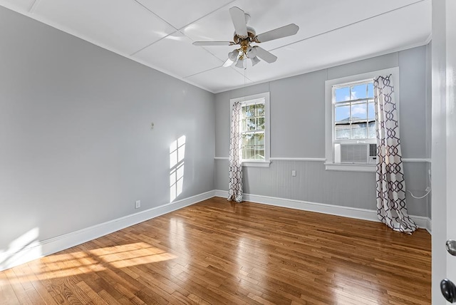 empty room featuring ceiling fan, cooling unit, and hardwood / wood-style flooring