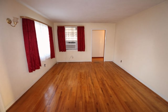 unfurnished room with cooling unit and wood-type flooring