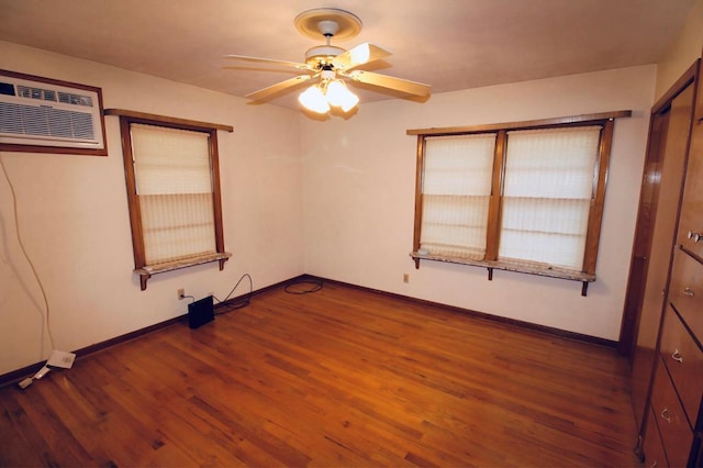 unfurnished bedroom featuring dark hardwood / wood-style flooring and an AC wall unit