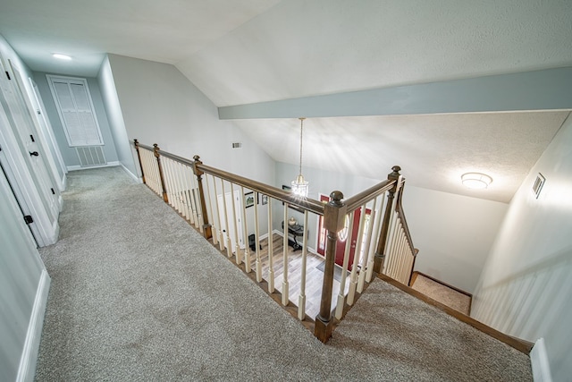 staircase with carpet floors, baseboards, lofted ceiling, and visible vents