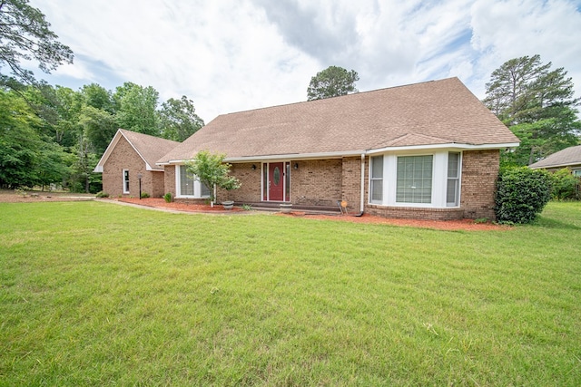 single story home featuring brick siding, roof with shingles, and a front yard