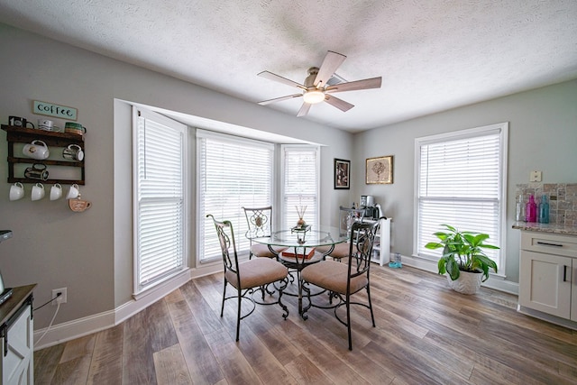 dining area featuring a ceiling fan, baseboards, a healthy amount of sunlight, and wood finished floors