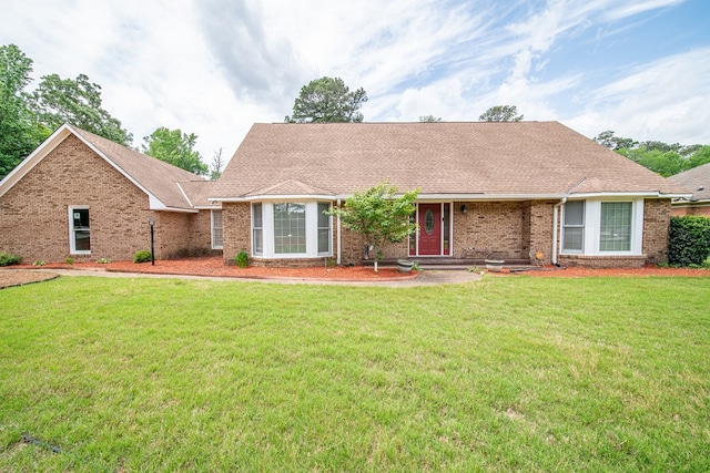 ranch-style home with brick siding, roof with shingles, and a front lawn