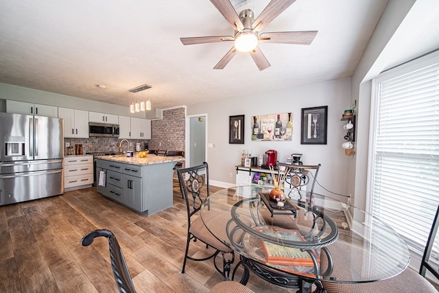 dining room with dark wood-type flooring, a ceiling fan, baseboards, and visible vents