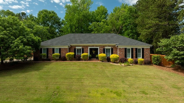 ranch-style home featuring brick siding and roof with shingles