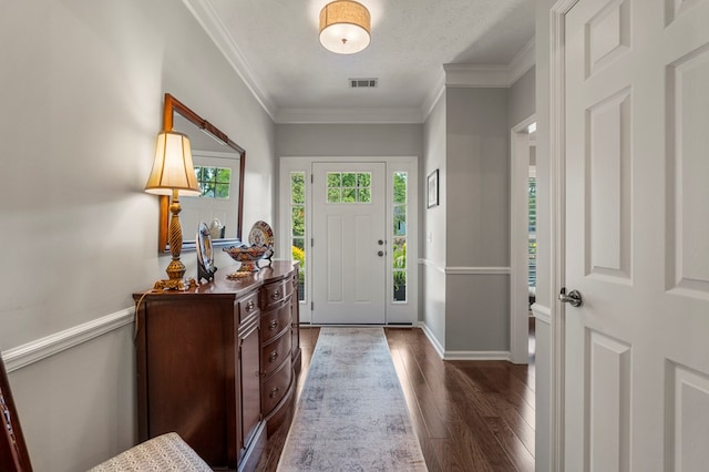 foyer entrance with dark wood-type flooring, ornamental molding, and baseboards