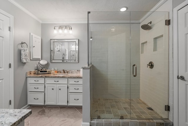 full bathroom with ornamental molding, vanity, a stall shower, baseboards, and a textured ceiling