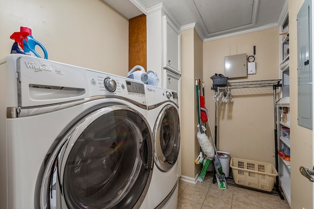 laundry area with cabinet space, washer and dryer, light tile patterned floors, crown molding, and baseboards