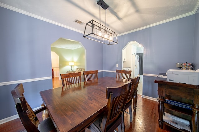 5728 Lexington Dr, Columbus, GA 31907 - dining area featuring arched walkways, dark wood-style flooring, ornamental molding, and a chandelier