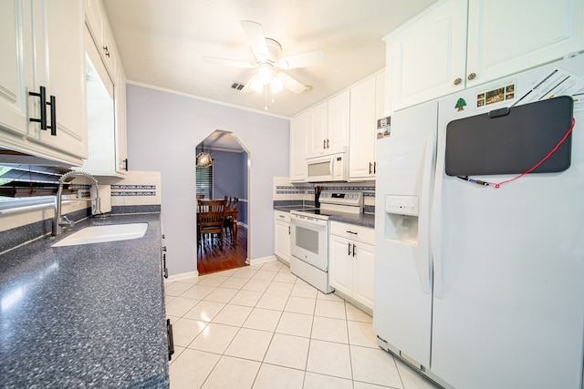 5728 Lexington Dr, Columbus, GA 31907 - kitchen with white appliances, dark countertops, arched walkways, a ceiling fan, and decorative backsplash