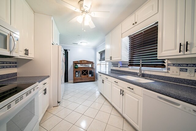 5728 Lexington Dr, Columbus, GA 31907 - kitchen featuring white appliances, dark countertops, light tile patterned flooring, ceiling fan, and white cabinets