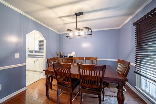 5728 Lexington Dr, Columbus, GA 31907 - dining area featuring light wood-style floors, crown molding, and arched walkways