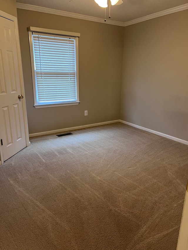 empty room featuring carpet flooring, ceiling fan, and ornamental molding