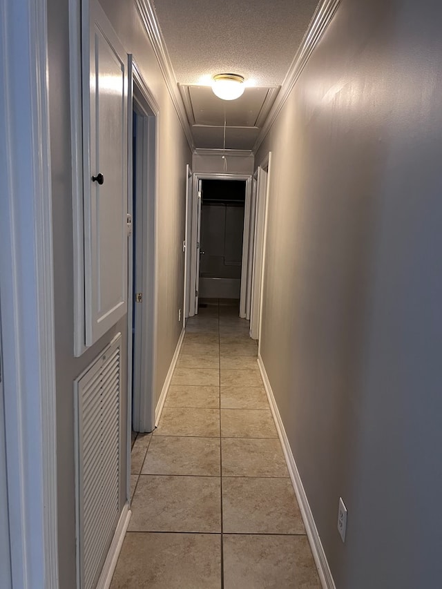 hall featuring crown molding, light tile patterned floors, and a textured ceiling