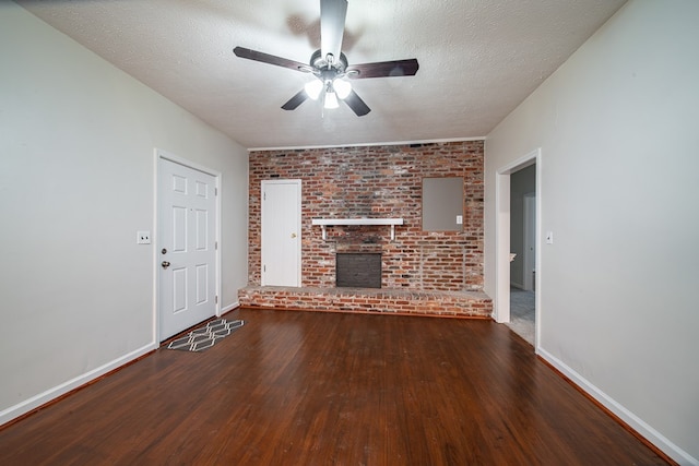 unfurnished living room featuring hardwood / wood-style floors, ceiling fan, a textured ceiling, and a brick fireplace