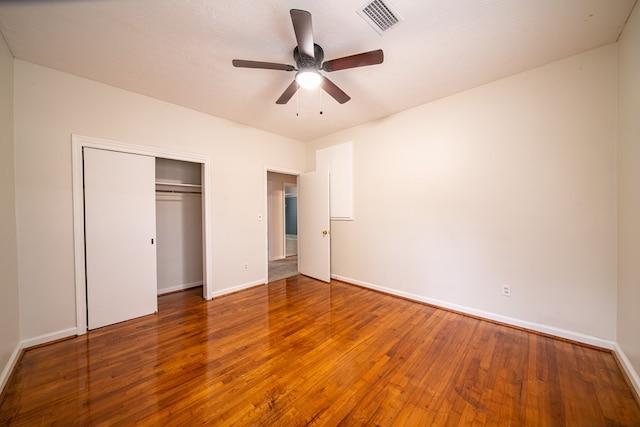 unfurnished bedroom with hardwood / wood-style floors, ceiling fan, and a closet