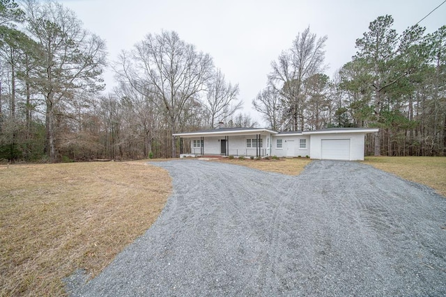 single story home with a front lawn, a porch, and a garage