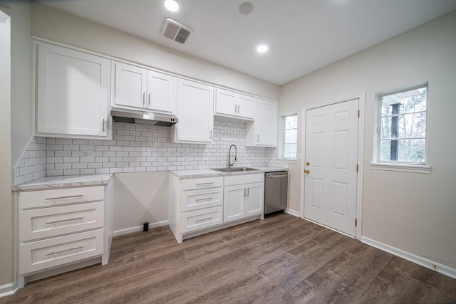 kitchen with decorative backsplash, dark hardwood / wood-style flooring, stainless steel dishwasher, sink, and white cabinets