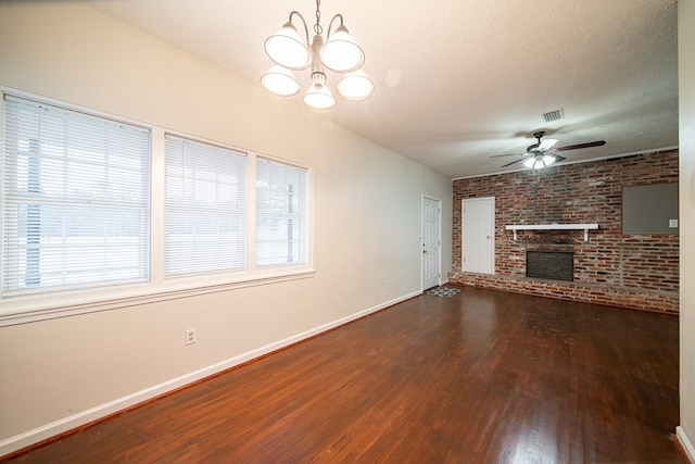 unfurnished living room featuring brick wall, a textured ceiling, ceiling fan with notable chandelier, hardwood / wood-style flooring, and a fireplace