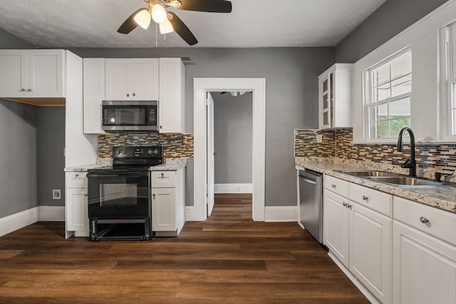 kitchen featuring stainless steel appliances, white cabinetry, and a sink