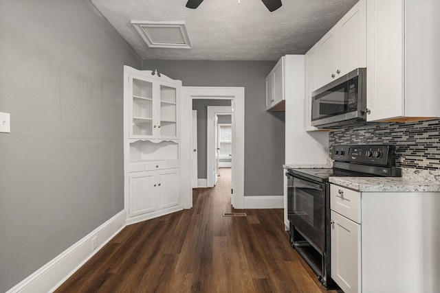 kitchen featuring electric range, white cabinets, decorative backsplash, dark wood-style floors, and stainless steel microwave