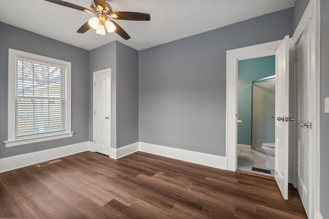 unfurnished bedroom with baseboards, visible vents, connected bathroom, dark wood-type flooring, and a textured ceiling