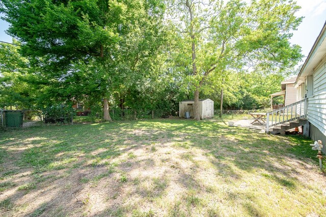 view of yard with an outbuilding, a shed, and a fenced backyard