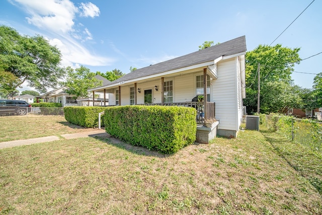 view of front of house with covered porch, fence, central AC unit, and a front lawn