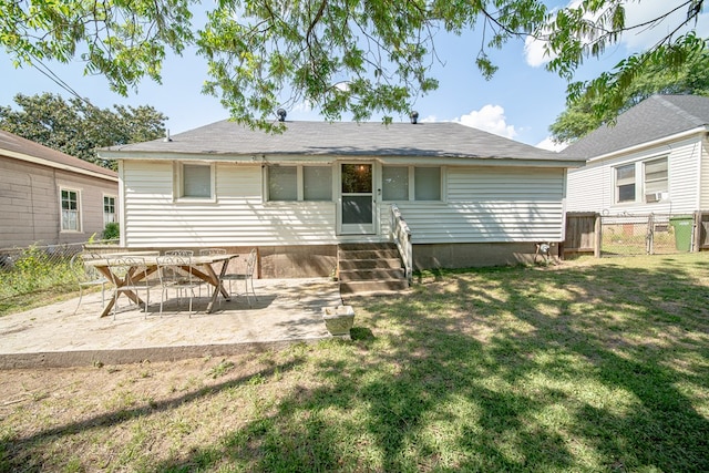 back of property with entry steps, fence, a patio, and a yard
