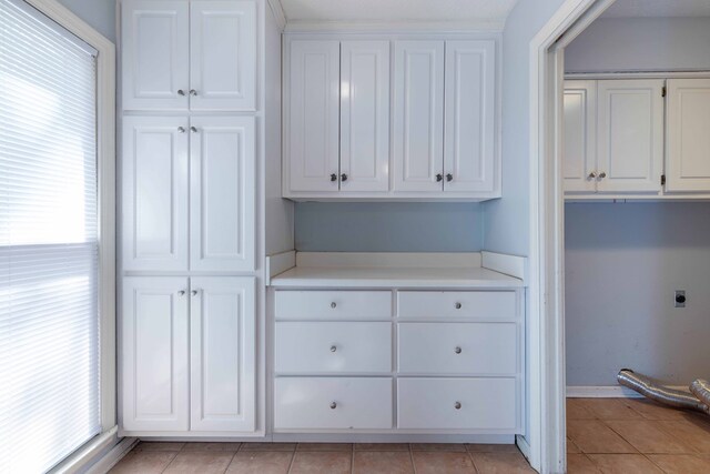 767 River Oaks Ct, Columbus, GA 31904 - laundry area with cabinet space, electric dryer hookup, and light tile patterned floors