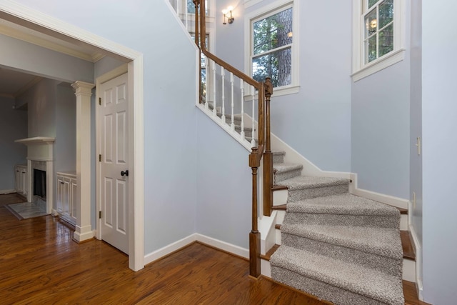 767 River Oaks Ct, Columbus, GA 31904 - stairway featuring wood finished floors, crown molding, and a fireplace with flush hearth
