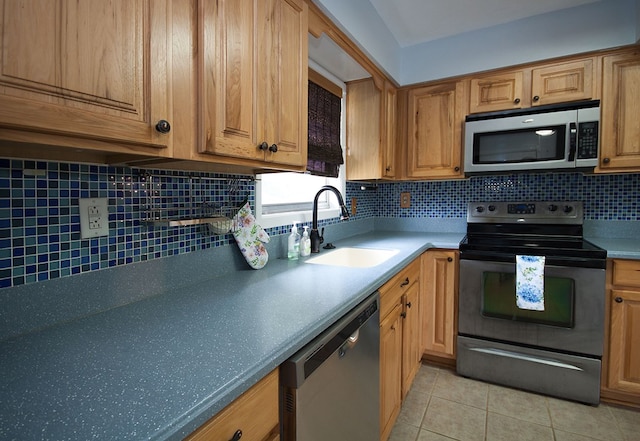 5622 Pollman St, Columbus, GA 31907 - kitchen featuring stainless steel appliances, light tile patterned floors, backsplash, and brown cabinets