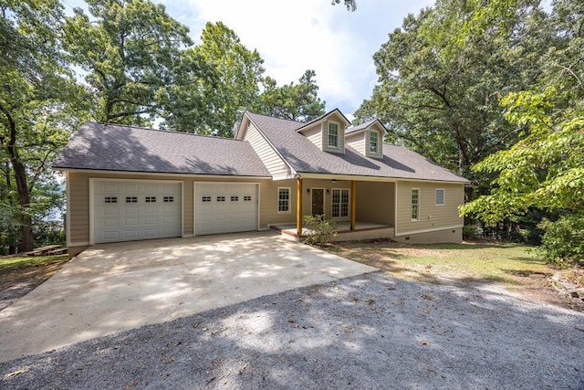 new england style home featuring covered porch and a garage