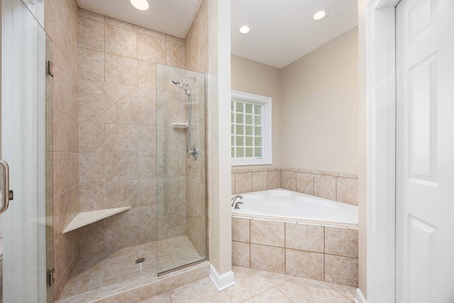 bathroom with a textured ceiling, separate shower and tub, and tile patterned floors