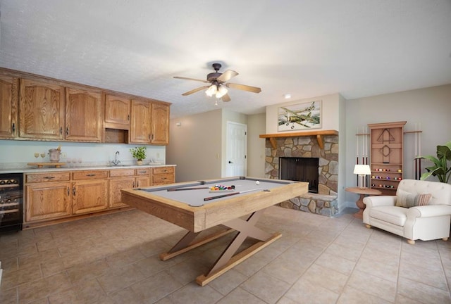 recreation room with ceiling fan, sink, a fireplace, wine cooler, and pool table